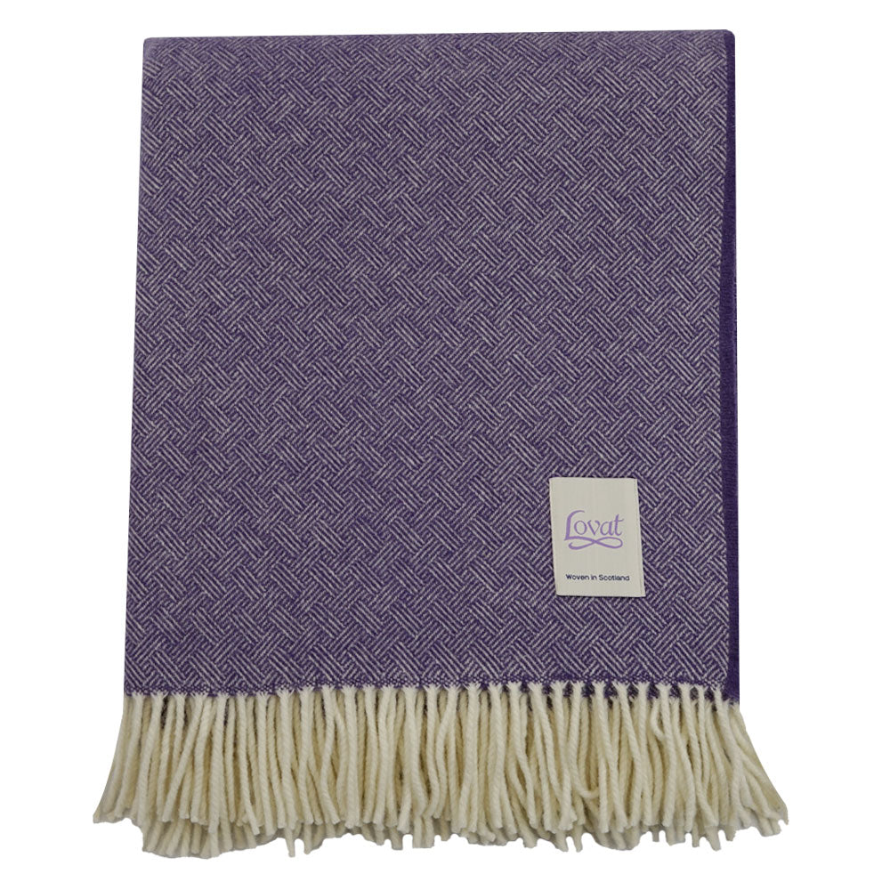 A folded 100% Lambswool blanket in purple.