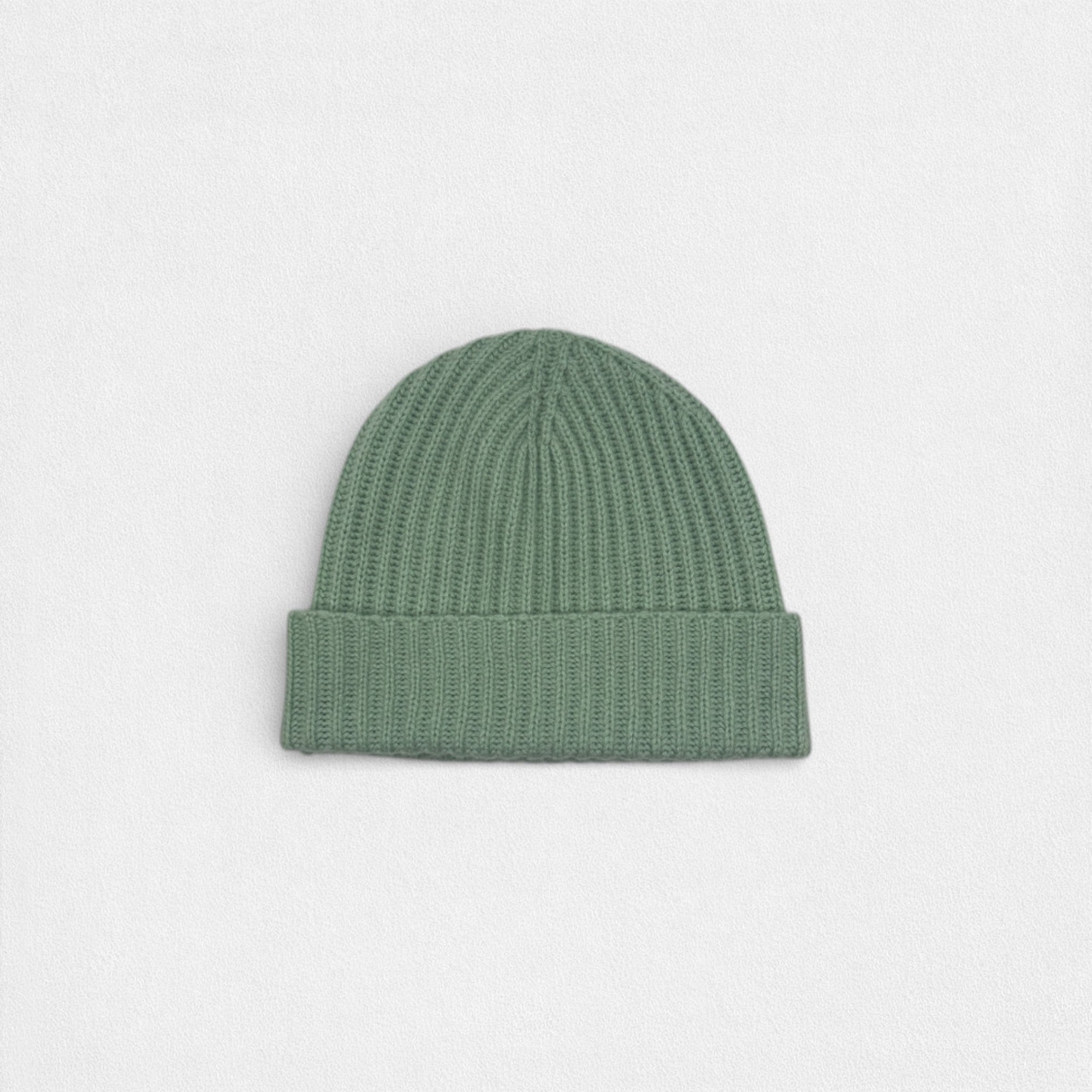 Green knit beanie on a light gray background