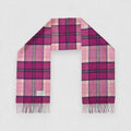 A Billet Pink tartan scarf made of 100% lambswool, displayed on a plain background, with a pattern of soft pink and rich grey lines crossed by lighter tartan stripes, and fringes at the ends.