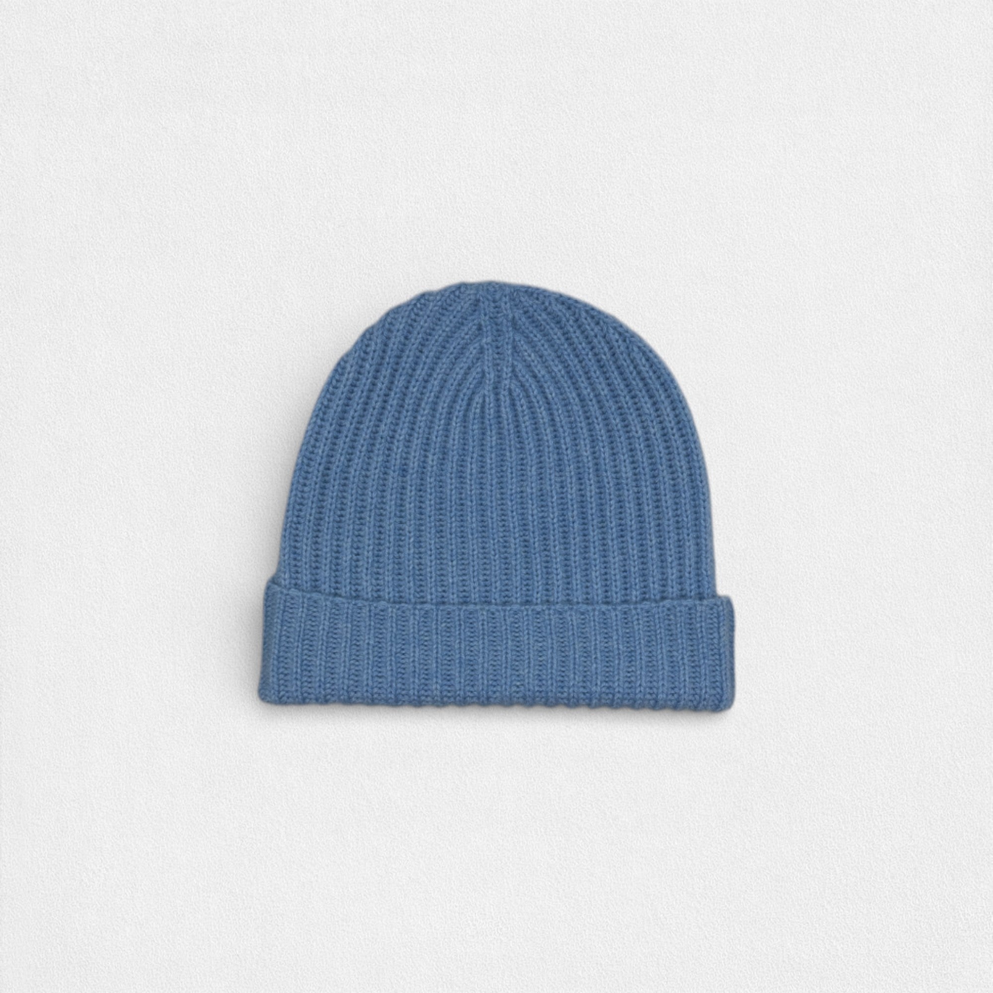 Blue knit beanie on a light gray background