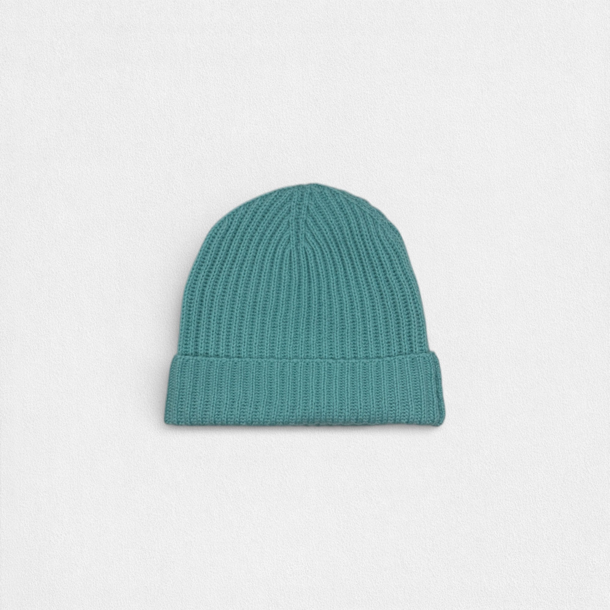 Teal knit beanie on a light gray background