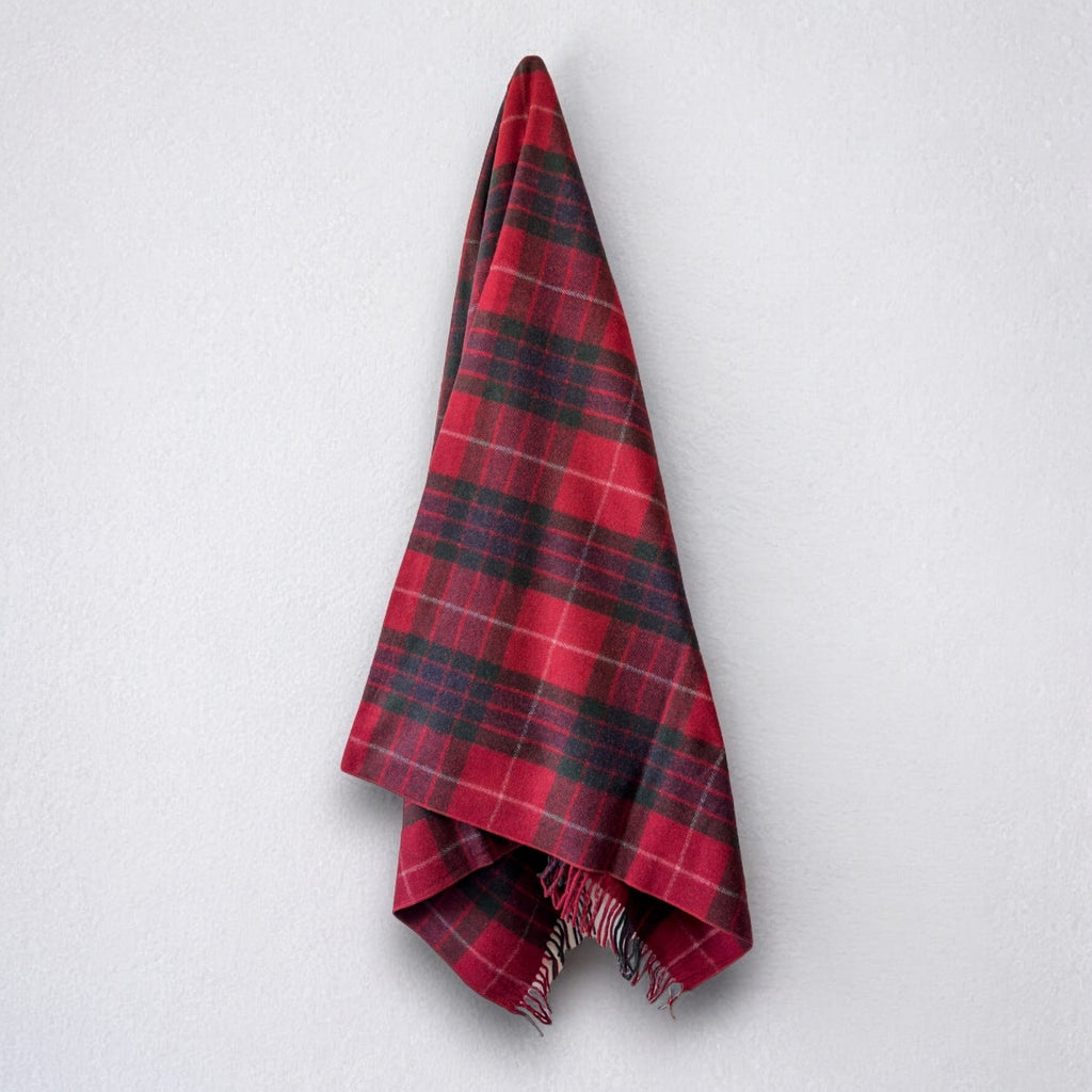 a 100% recycled blanket in fraser red tartan hanging from a wall hook on a white background 