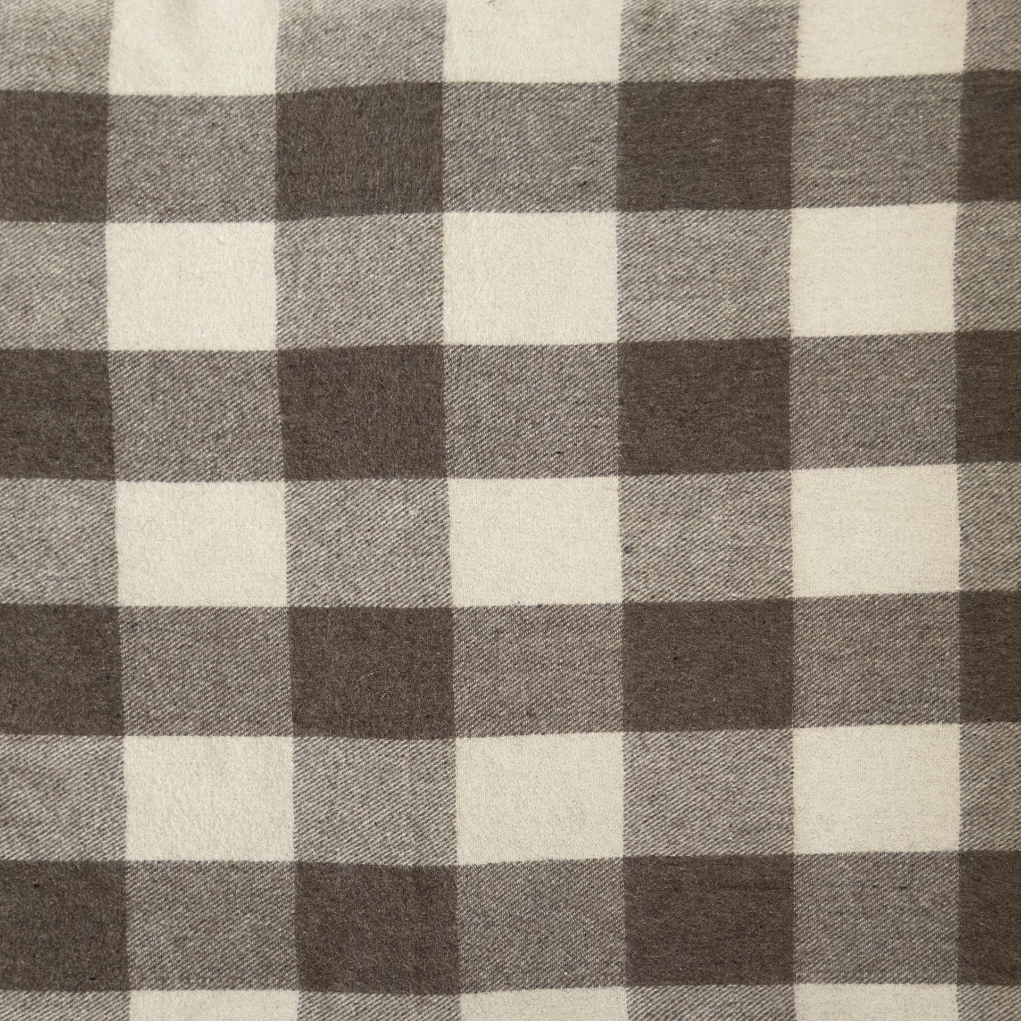 A close up example of the Jacob tartan. Jacob tartan has hues of cream, brown and grey in. a checked pattern.