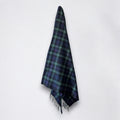 a 100% recycled blanket in mackenzie tartan hanging from a wall hook on a white background 
