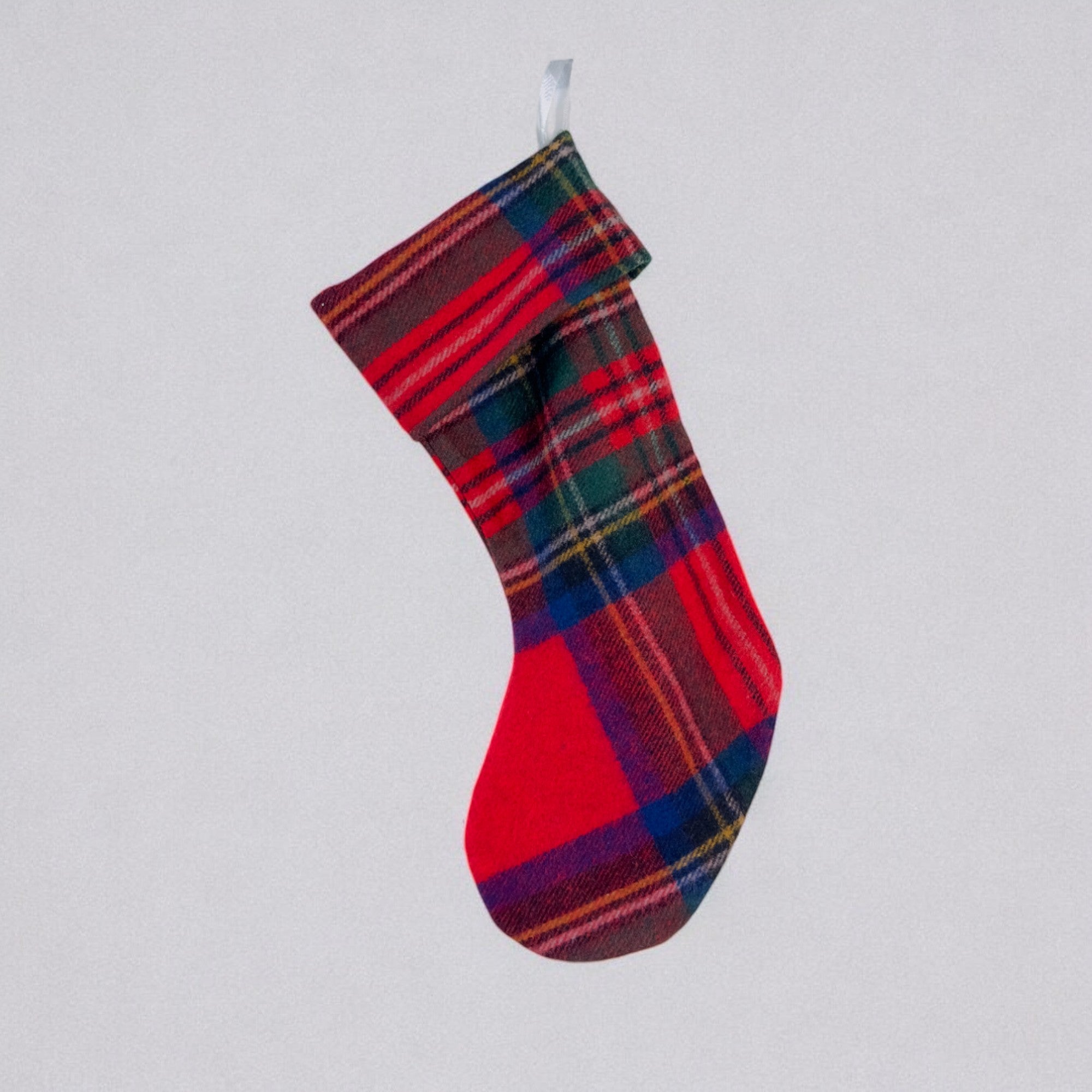 The Royal Stewart Tartan Christmas stocking hanging against a grey background.