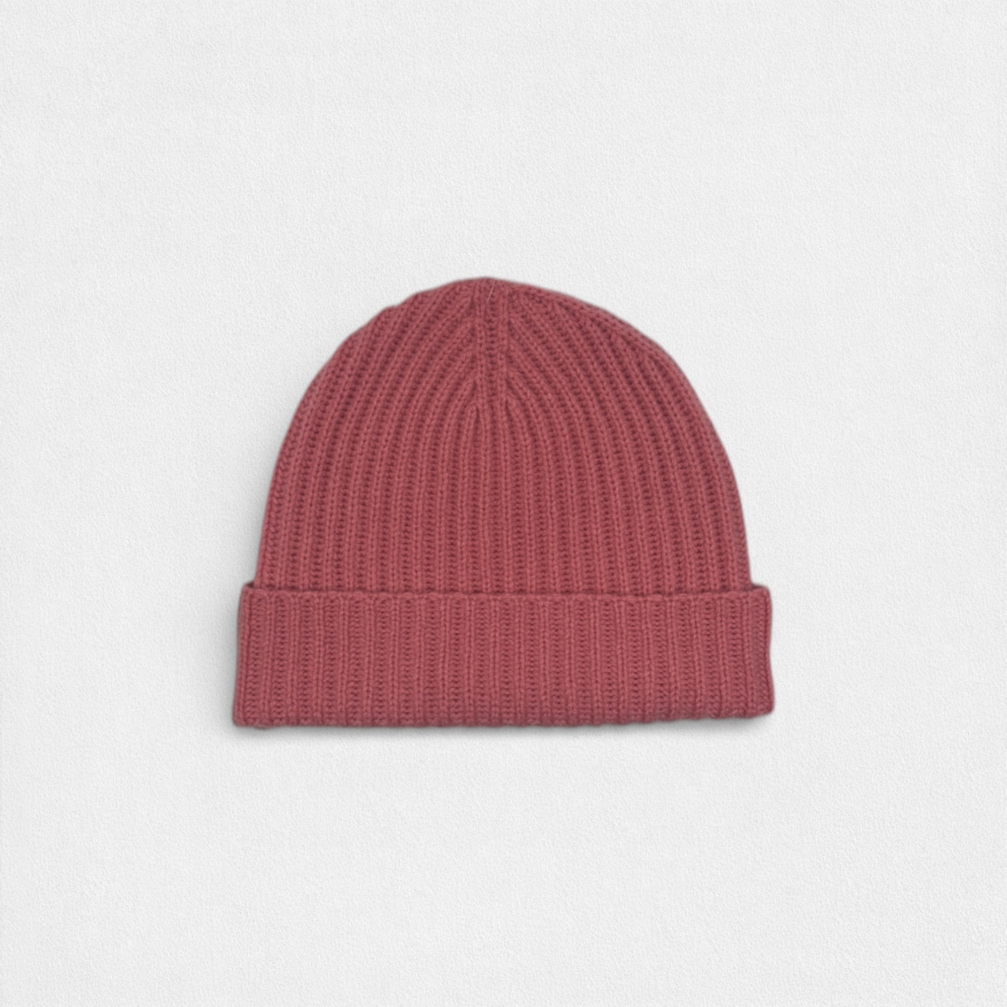Pink knit beanie on a light gray background