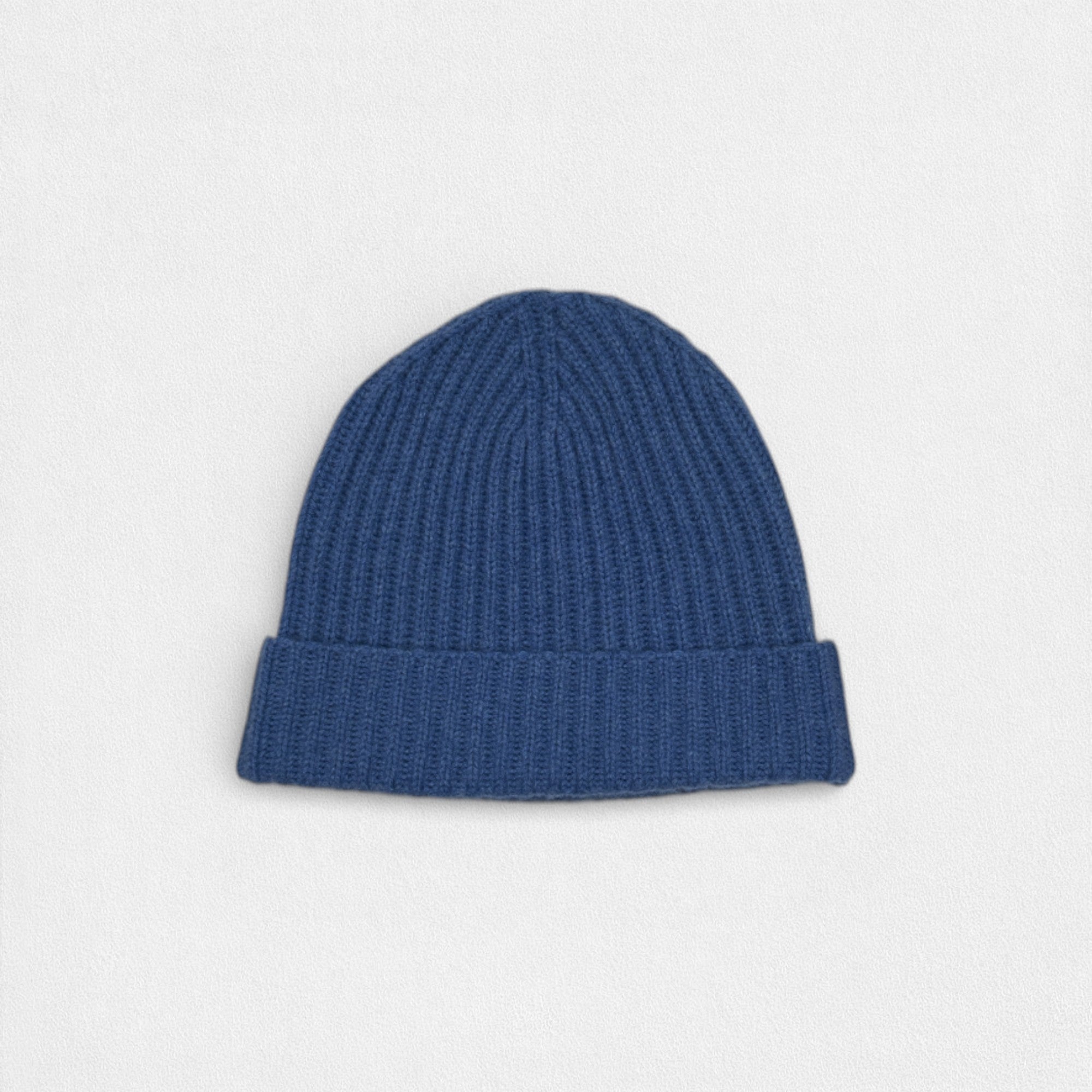 Blue knit beanie on a light gray background